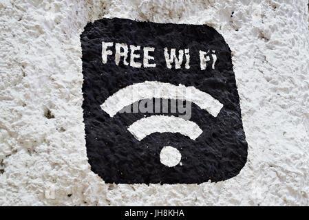 Signo negro de Wi-Fi gratuito en una pared de piedra blanca Foto de stock