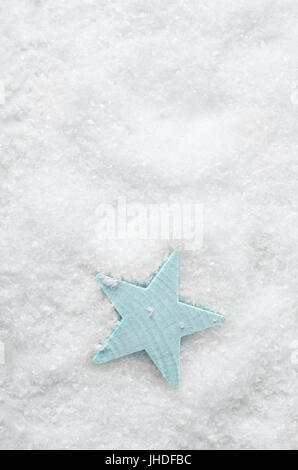 Imagen de fondo de Navidad. Fotografía cenital de un azul pálido madera de estrella blanca nieve artificial con copia espacio encima.