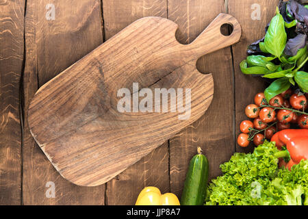 Vista superior de verduras y hortalizas con placa de corte de madera. Fondo de alimentos saludables Foto de stock
