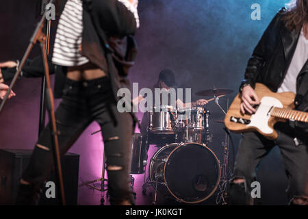 Los jóvenes de la banda de rock and roll de la realización de la música rock en el escenario