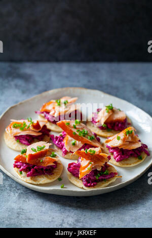 Blinis con remolacha, rábano picante, salmón ahumado en caliente y cabra chhese
