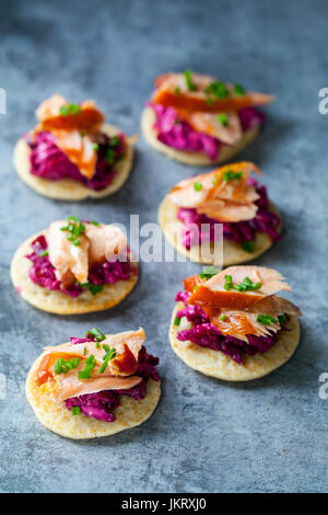 Blinis con remolacha, rábano picante, salmón ahumado en caliente y cabra chhese