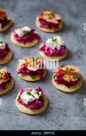 Blinis con remolacha, rábano picante, salmón ahumado en caliente y cabra chhese
