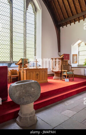 Pila bautismal de piedra mostrando interior, el altar y el púlpito de madera de la Iglesia Parroquial de Balquhidder, Stirling, Escocia, Reino Unido Foto de stock