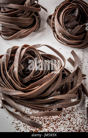 Materias desprevenidos chocolate pasta de fideos. En una cocina blanca mesa de mármol. Espacio de copia Foto de stock