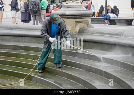 El Departamento de Parques de la ciudad de Nueva York trabajador poder lavar el área alrededor de la fuente en el parque Washington Square en Greenwich Village, Nueva York. Foto de stock