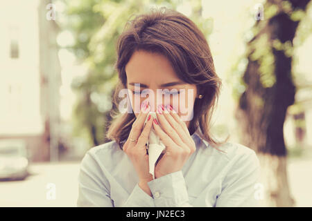 Las mujeres con síntomas de alergia sonarse la nariz Foto de stock