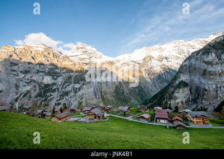 Alquería en la aldea de montaña de nieve de los alpes suizos en el fondo en Grindelwald, Suiza. Aldea Rural en Suiza. Foto de stock