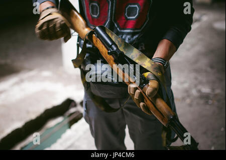 Hombre con ropa táctica disparando desde una pistola, volviendo a cargar la  pistola y apuntando al objetivo en la zona de tiro de puerta abierta  Fotografía de stock - Alamy