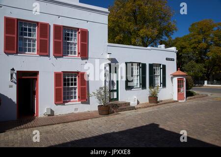 Arquitectura histórica en Graaff-Reinet, Eastern Cape, Sudáfrica. Edificio blanco de estilo holandés del Cabo con contraventanas pintado de colores vivos. Foto de stock