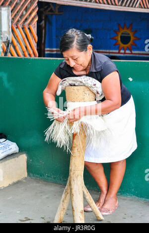 Mujer tejiendo a mano un sombrero de paja toquilla, nr Cuenca
