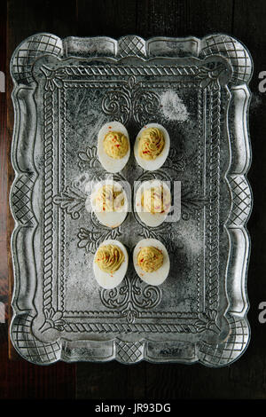 Deviled huevos caseros con pimentón en bandeja de plata