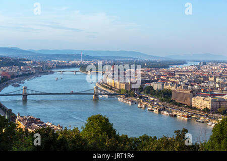 Vista desde la colina Gellert sobre el Danubio hacia Pest y el edificio del Parlamento con la cadena puente que cruza el río, Budapest,Hungría Foto de stock