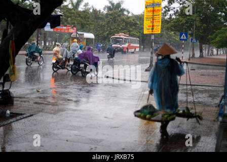 Las lluvias del monzón en la ciudad de Hue. La gente a lo largo de calles inundadas iwalking en Hue. Vietnam. Foto de stock