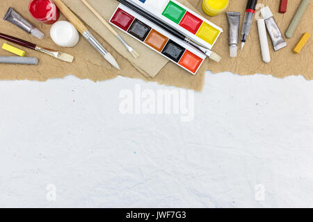 Diversas herramientas de dibujo artístico colorido sobre papel reciclado antecedentes, vista superior Foto de stock