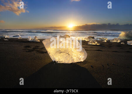 Bloque de hielo en la playa negra en la Laguna glaciar Jokulsarlon al amanecer, Islandia, Europa oriental