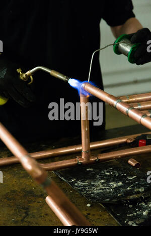 Fontanero soldar cobre tuberías de agua usando un soplete en un hogar, la  estera heatproof protege otras tuberías Fotografía de stock - Alamy