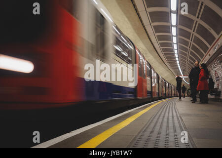 Plataforma de metro de Londres con el tren en movimiento. Londres, 2017. El formato horizontal. Foto de stock