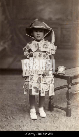Retrato de estudio, Little Girl en Ye Olde English Garden traje (según el anuncio que sostiene). Fecha: circa 1910s
