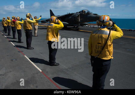 170822-N-RU971-294 MAR DEL CORAL (22 de agosto, 2017) departamento de aire marineros saludan al piloto de un avión AV-8B Harrier, asignado a la "Tomcats" del escuadrón de ataque marino (VMA) 311, antes de que despega desde la cubierta de vuelo del buque de asalto anfibio USS Bonhomme Richard (LHD 6). VMA-311 concluye su "Farewell Tour" con el Bonhomme Richard Expeditionary Strike Group (HRB ESG) y el 31º Grupo de ataque Expedicionaria de la Marina (MEU) como las transiciones de ESG A F-35B Lightning II Joint Strike Fighters en el invierno de 2017. Bonhomme Richard, buque insignia de la HRB ESG, está operando en el Pacífico Indo-Asia volver Foto de stock