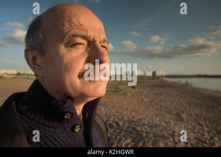 Retrato de hombre de mediana edad de relax en la naturaleza en el día de verano y mirar lejos en la distancia