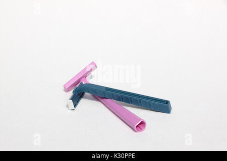 Schick azul y rosa desechables navaja de afeitar desechables Bic ambas hechas del plástico, polipropileno. Foto de stock
