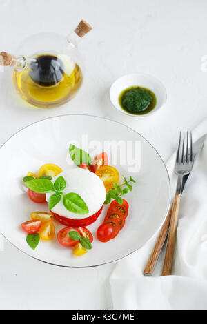 Ensalada Caprese con tomates cereza madura y queso mozzarella con hojas de albahaca fresca aislado en el fondo blanco. Vista desde arriba. Foto de stock