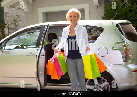 Mujer con bolsas en el coche
