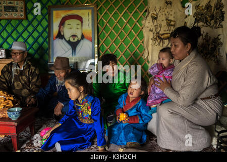 Mongolia interior, China-Julio 26, 2017: familia mongólica vestidos tradicionalmente sentado en su tienda (denominado como yurt). Foto de stock