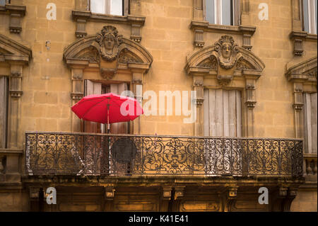 Sombrilla roja en el balcón, Sarlat-la-Caneda, Dordogne, Francia Foto de stock