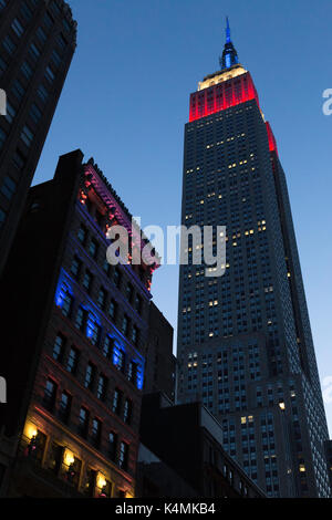 El Empire State Building se cierne sobre el edificio ditson al anochecer, en la ciudad de Nueva York, EE.UU.