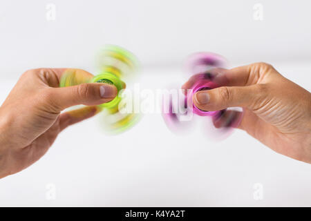 Cerca de manos jugando con molestar spinners Foto de stock