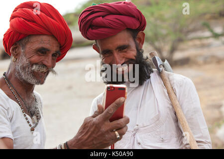 Dos hombres rabari divertidos por un celular Foto de stock
