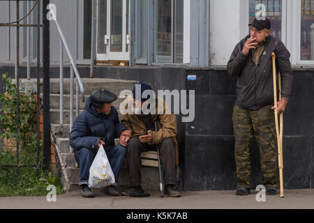 Kazan, Rusia - 9 de septiembre de 2017: tres mendigos sin hogar hombres tener un descanso cerca de la tienda de comestibles Foto de stock