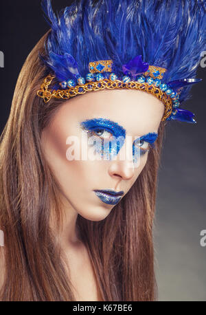 Maquillaje de moda en el estilo de los indios americanos. Mujer atractiva  con maquillaje con plumas de color azul brillante Fotografía de stock -  Alamy