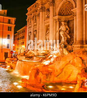 Sorprendentemente escena nocturna de la fontana di Trevi iluminada en el casco antiguo de Roma, Italia.