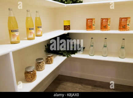 Un paseo en la despensa de la cocina modelo con jarras, botellas de vino y cajas de alimentos. Foto de stock