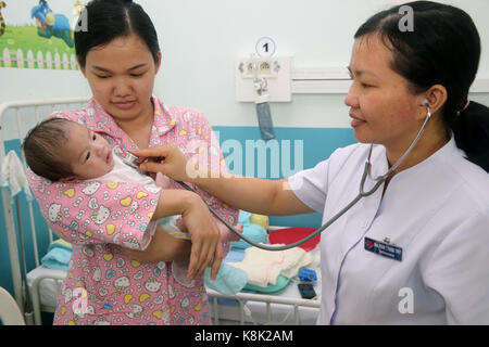 El instituto del corazón ofrece una atención de alta calidad a los pacientes vietnamitas que sufren de enfermedades cardíacas. Médico que escucha el corazón de un bebé. Ciudad ho chi minh. vietnam. Foto de stock