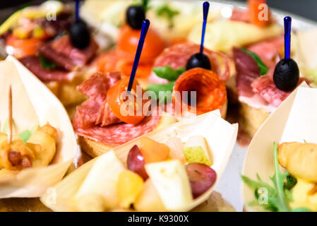 Canapés caseros sandwiches pequeños aperitivos. Mezcla de diferentes finger food bocadillos para una fiesta o banquete en una placa.