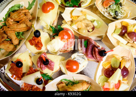 Canapés caseros sandwiches pequeños aperitivos. Mezcla de diferentes finger food bocadillos para una fiesta o banquete en una placa.