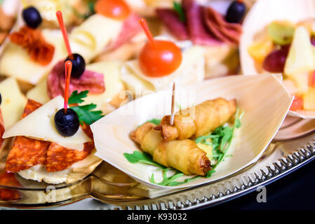 Canapés caseros sandwiches pequeños aperitivos. Mezcla de diferentes finger food bocadillos para una fiesta o banquete en una placa.