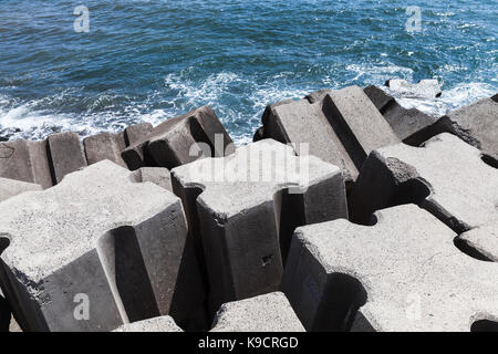 Bloques de hormigón en bruto como parte del rompeolas de estructura para la protección del océano olas Foto de stock