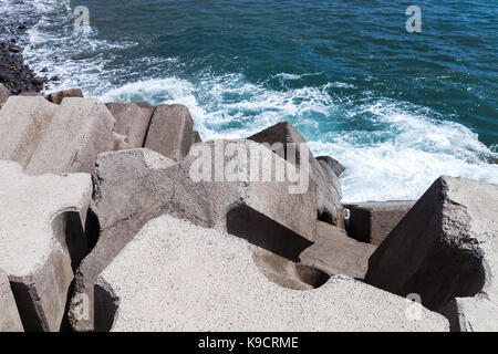 Enormes bloques de hormigón como parte del rompeolas de estructura para la protección del océano olas Foto de stock