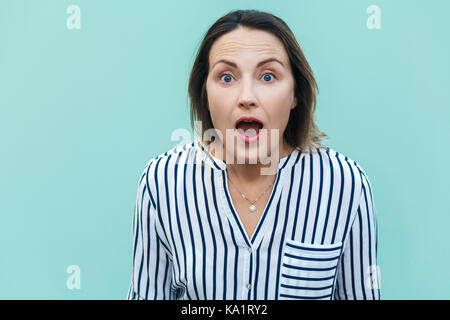 Wow! Sorprendido y consternado hermosa mujer adulta mirando a la cámara con cara de escandalizado. aislado sobre fondo de color azul claro.