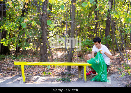 Sofia, Bulgaria - 16 septiembre, 2017: joven recoge la basura en el bosque que participan en una campaña de limpieza Limpieza en persona. La ecología del parque. Foto de stock