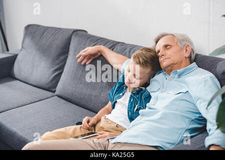 Abuelo y nieto durmiendo en el sofá Foto de stock