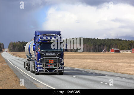 Jokioinen, Finlandia - 23 de abril de 2017: azul oscuro scania r580 un camión tanque con bull bar en adr lance a lo largo de carretera recta a través del paisaje rural en el sur de s Foto de stock