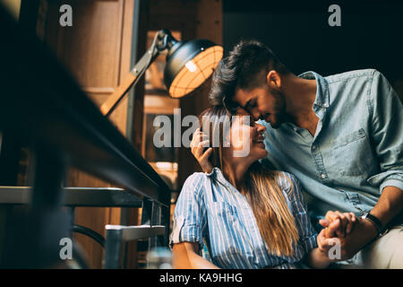 Pareja sonriente en el amor en un columpio al aire libre, hombre bese su  frente de mujer Fotografía de stock - Alamy