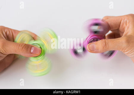 Cerca de manos jugando con molestar spinners Foto de stock