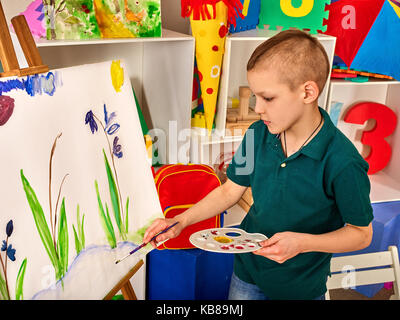 Pintura infantil en el caballete .: fotografía de stock